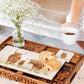 A rectangle marble sharing platter with a highland cow family watercolour design being used to serve breakfast.