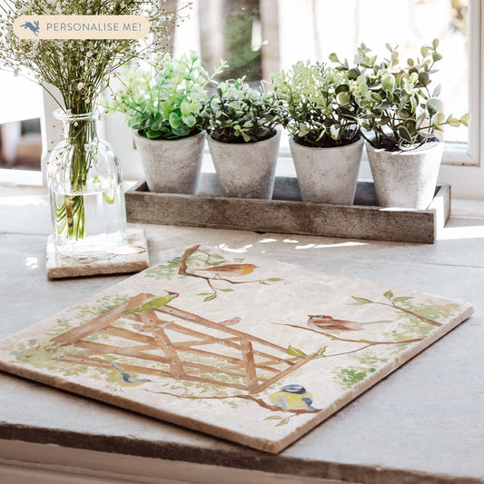 A large marble platter with a watercolour design featuring British garden birds in the hedgerow around the paddock gate.