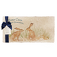 A personalised marble sharing platter featuring two kissing hares in a watercolour style, packaged with a luxurious dark blue bow and branded gift tag.