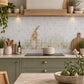A kitchen backsplash featuring a decorative tile mural with a rabbit in a grassy field, installed behind a black induction cooktop and light-colored stone countertop.