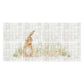 A rectangular wall art print or tile-style panel featuring a light brown rabbit standing among tall green grass in front of a white tiled background, shown against a plain white surround.