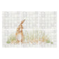 A square wall art print or tile-style artwork featuring a brown rabbit sitting in pale green grass against a light gray tiled background, shown on a white page-like backdrop.