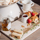 A rectangular marble sharing platter, featuring a watercolour design of robins. The platter is being used to serve afternoon tea.