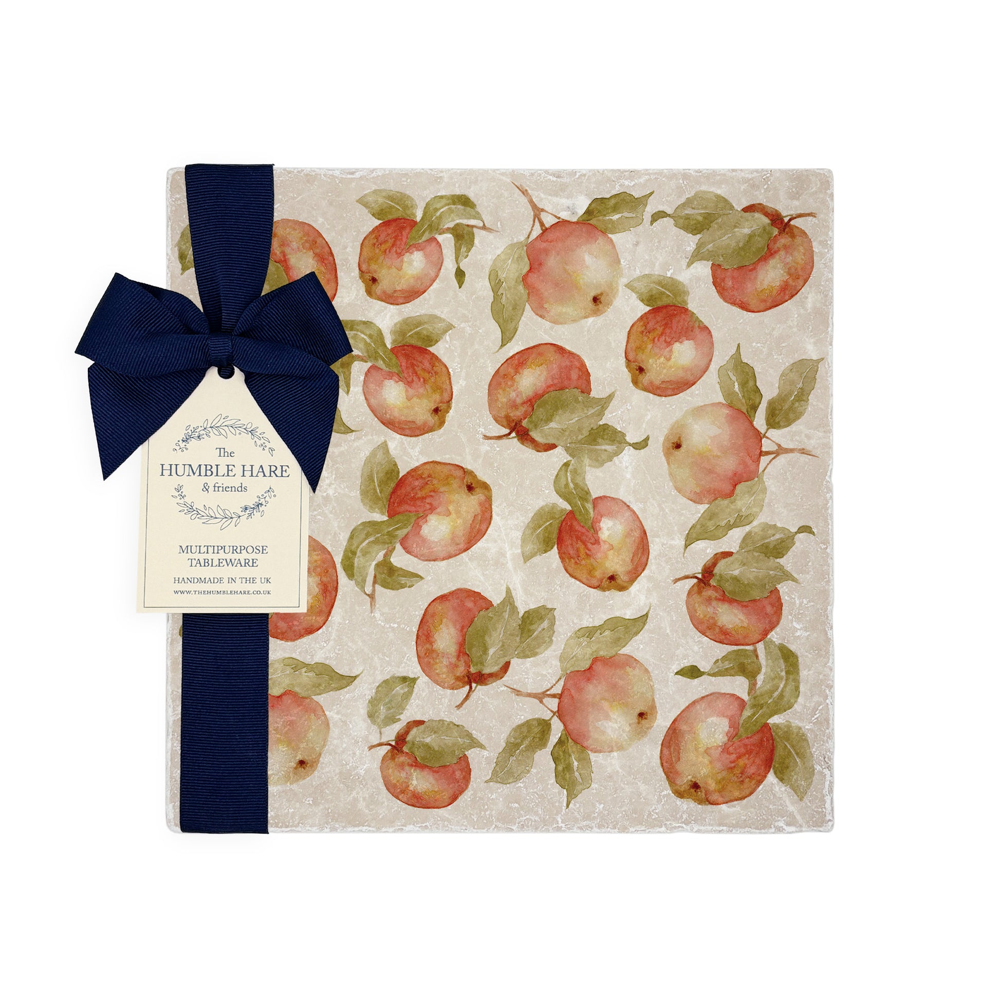 A sunny dinner table set with handmade marble platters featuring a watercolour pattern inspired by English apple orchards.