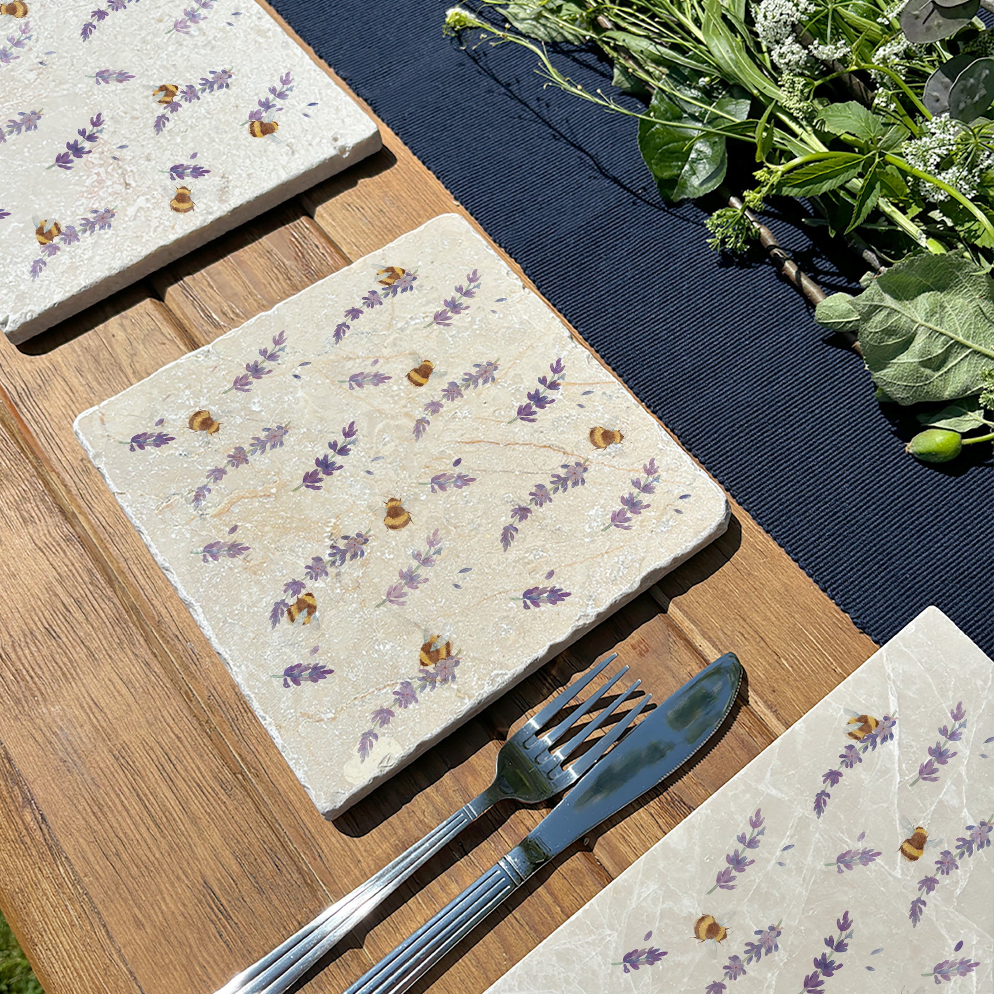 A multipurpose medium marble platter featuring a beautiful pattern of busy bees and purple lavender flowers, set on a garden table.