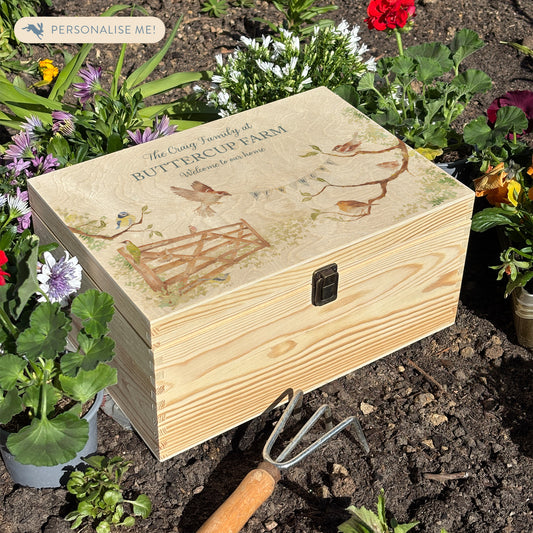 This medium sized wooden pine New home gift box can be filled with special gifts as a new home special occasion. The Design has a blue tit, robin, wren and sparrow on branches. There is a flying sparrow carrying a new home bunting. There is also a beautiful wooden gate opening to symbolise new beginnings with the gate opening. In the Garden new home gift.