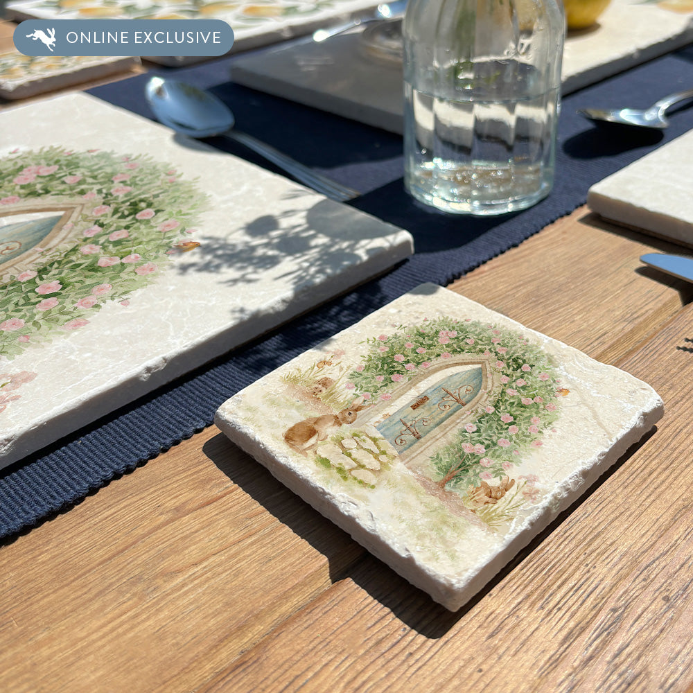 A square marble coaster featuring a  watercolour design of a rabbit showing the way to a  hidden door under a rose archway that leads into an enchanted garden.