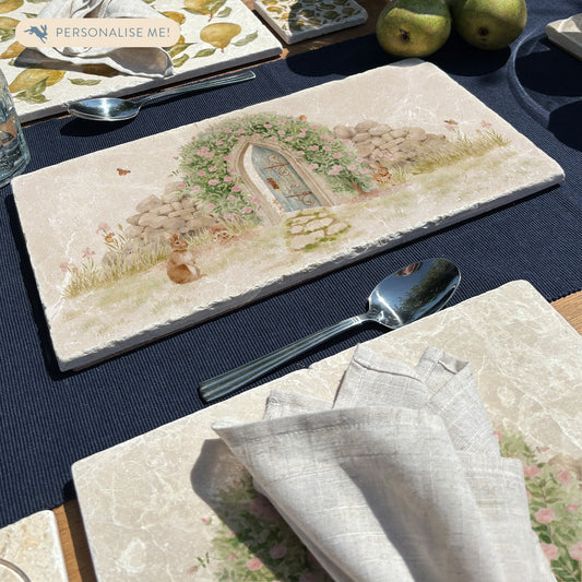 A rectangle marble sharing platter with a watercolour scene showing a hidden door under a rose archway leading to a secret garden.