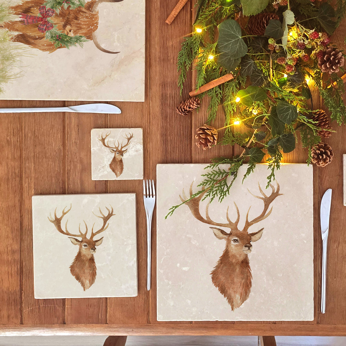 A set of four marble coasters with a watercolour illustration of a stag's head.