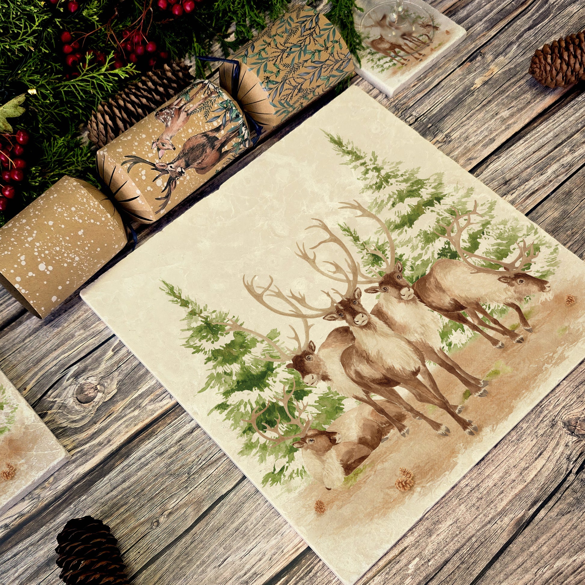 The Reindeers rest design features reindeer appearing from an opening in the wintery snowy forest. 
