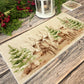 The Reindeers rest design features reindeer appearing from an opening in the wintery snowy forest. 