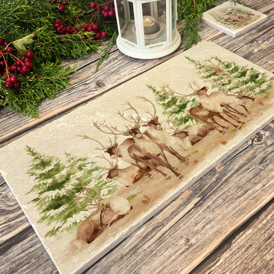 The Reindeers rest design features reindeer appearing from an opening in the wintery snowy forest. 