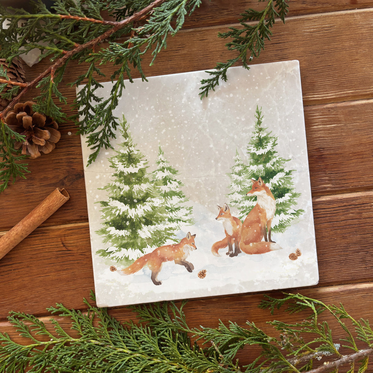 A medium marble platter featuring a forest scene with a family of foxes and fox cubs playing in the snow.