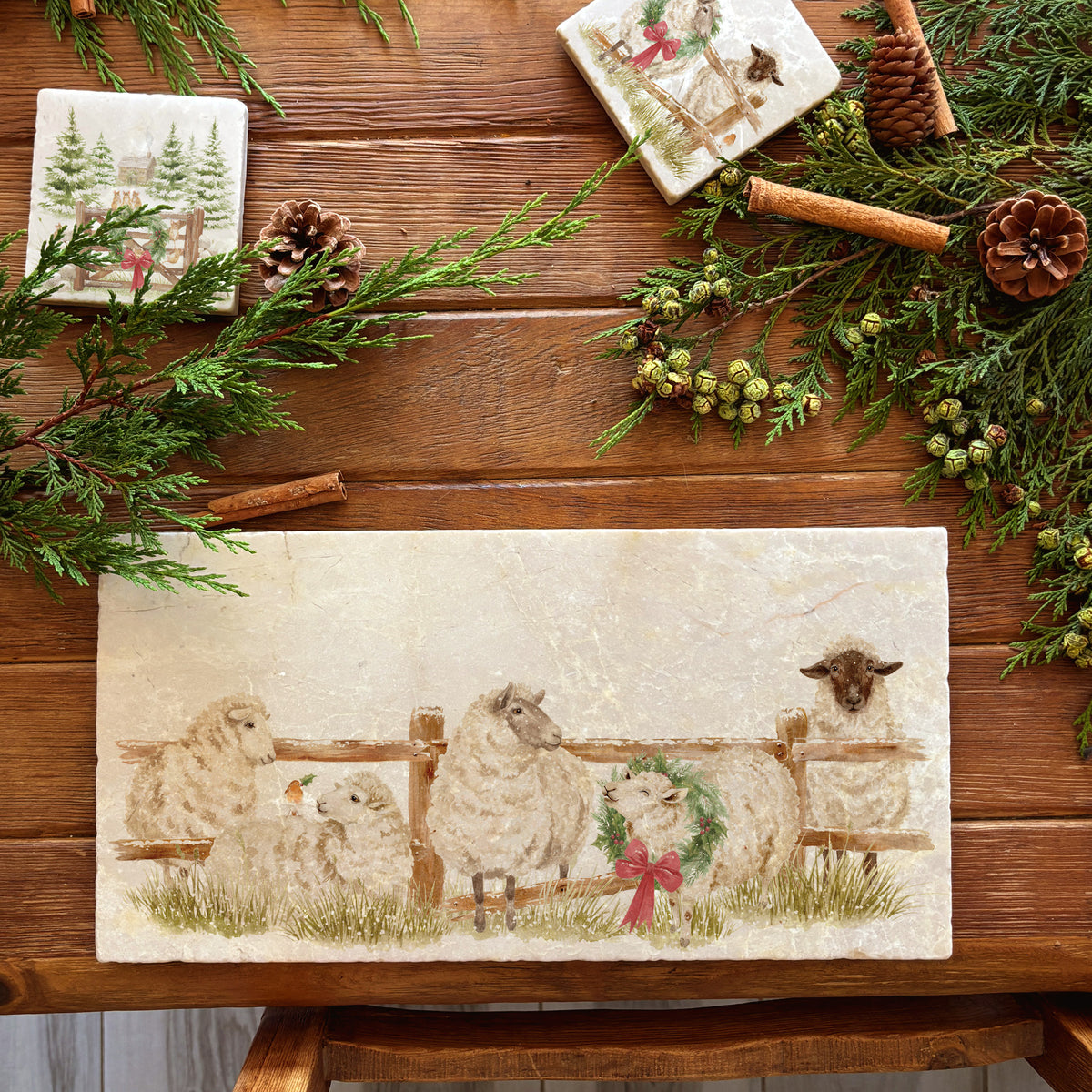 A rectangular marble sharing platter featuring a farmyard scene of sheep in the snow wearing a Christmas wreath.