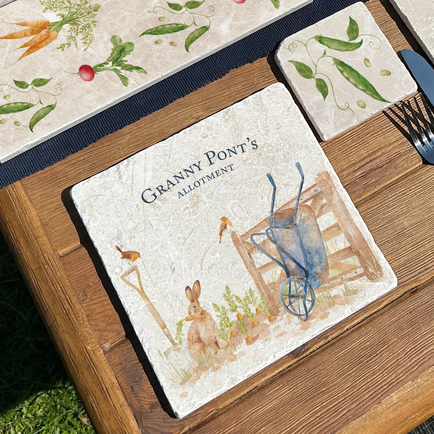 A medium personalised cream marble platter on a garden table, being used to serve bread. The platter has a watercolour vegetable patch design.