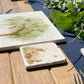 A square marble coaster featuring a watercolour scene of rabbits and a fawn.