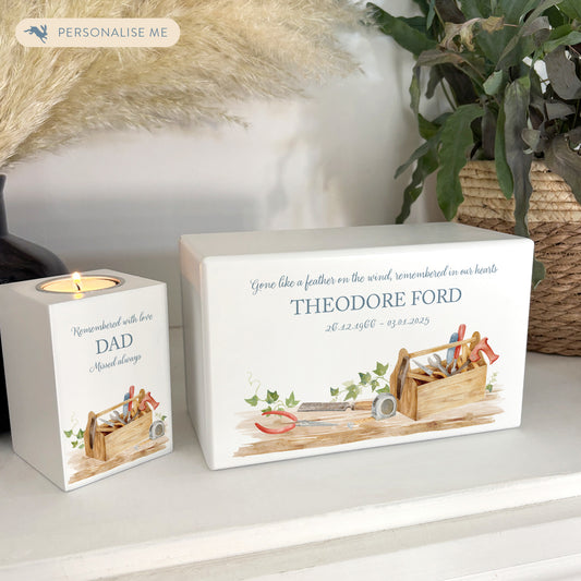 A beautifully crafted solid wooden urn, finished in white with a soft watercolour design Dads, Grandads, uncles, Brothers tool box, Thoughtfully made for either display or burial, this personalised urn can be customised to create a meaningful memorial. Perfect for holding ashes of a loved one or a beloved pet, it serves as a comforting tribute and keepsake.