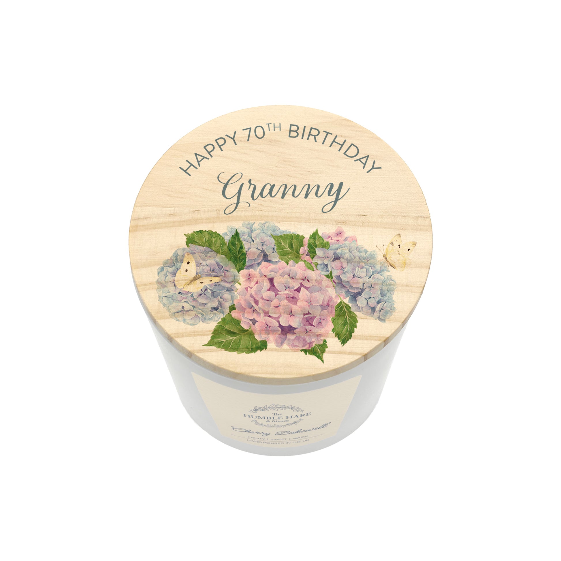 A personalised white glass candle jar with a light wood lid with an illustration of a bunch of blue and pink hydrangeas and the words Happy 70th Birthday Granny.