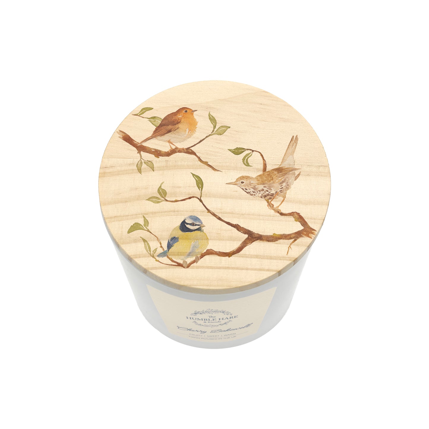 A white jar candle with a round light wood lid decorated with painted birds perched on branches, shown on a plain white background.