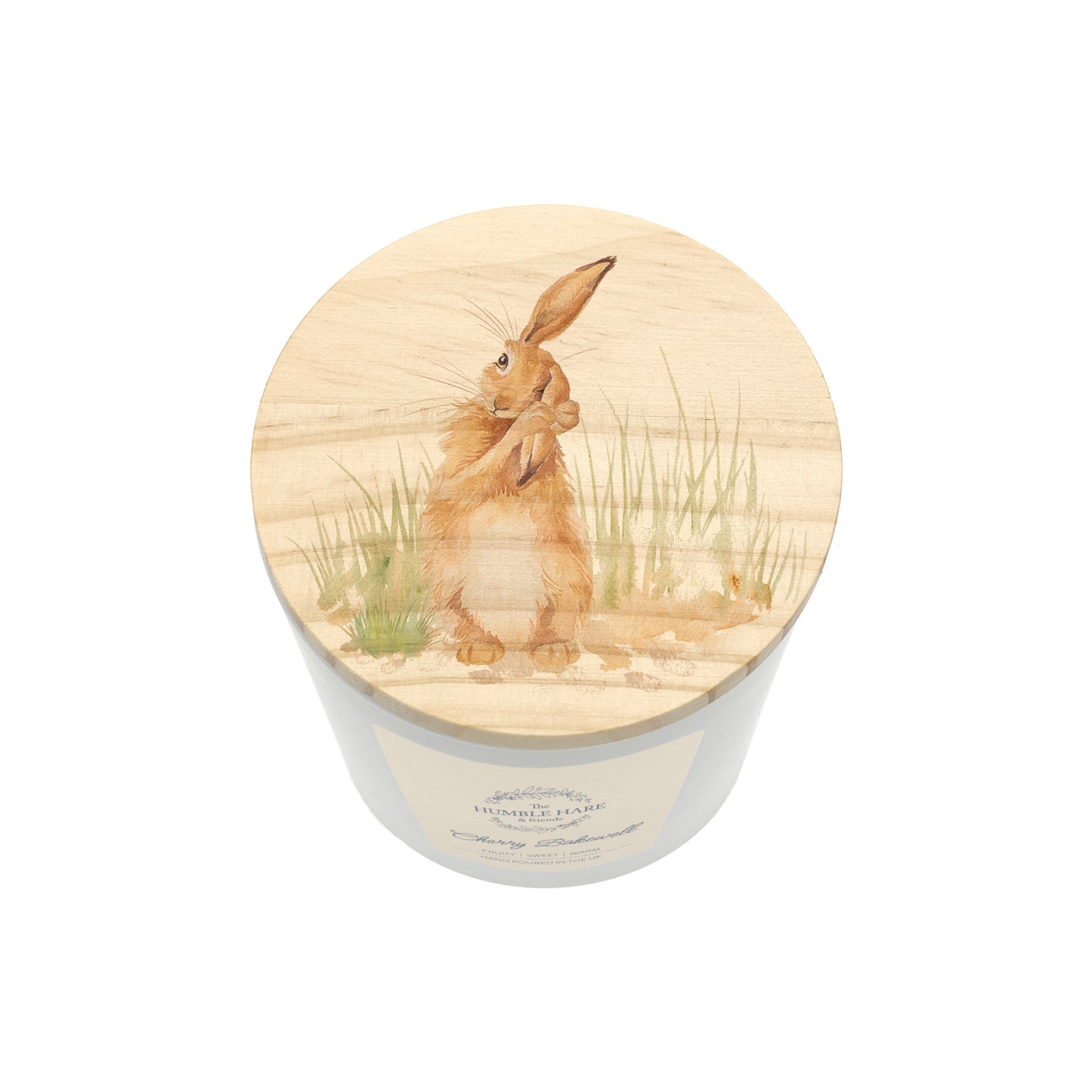 A white glass candle jar with a light wood lid with an illustration of a brown hare washing its ear in long grass.