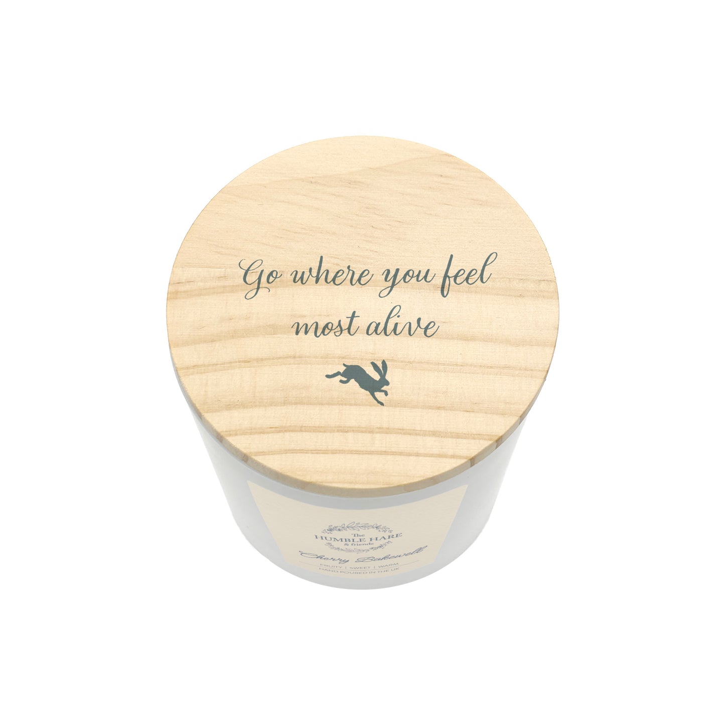 A jar candle with a light natural wood lid featuring the quote  'Go where you feel most alive' and a small hare silhouette, shown on a plain white background.