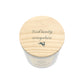 A white glass jar candle with a light natural wood lid with the phrase 'Find beauty everywhere' and a small leaping hare silhouette, shown on a plain white background.