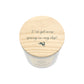A white glass jar candle with a light natural wood lid featuring the phrase 'I've got some spring in my step!' and a small hare silhouette, shown on a white background.