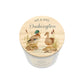 A personalised white glass candle jar with a light wood lid with an illustration of a duck couple, and the text 'Mr & Mrs Duckington'.