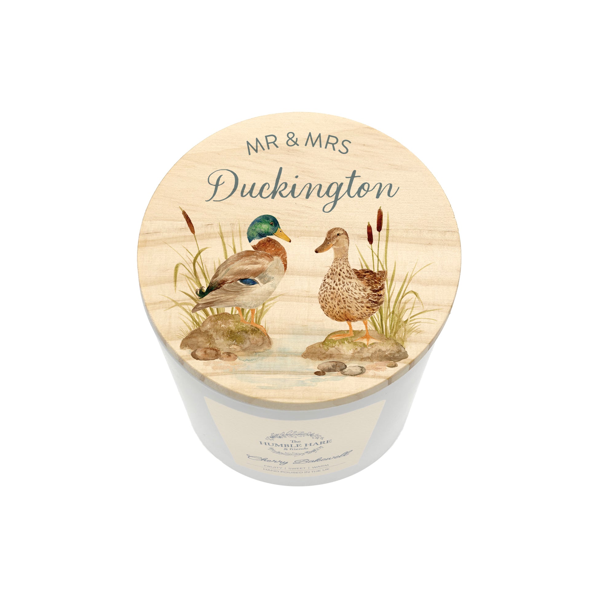 A personalised white glass candle jar with a light wood lid with an illustration of a duck couple, and the text 'Mr & Mrs Duckington'.